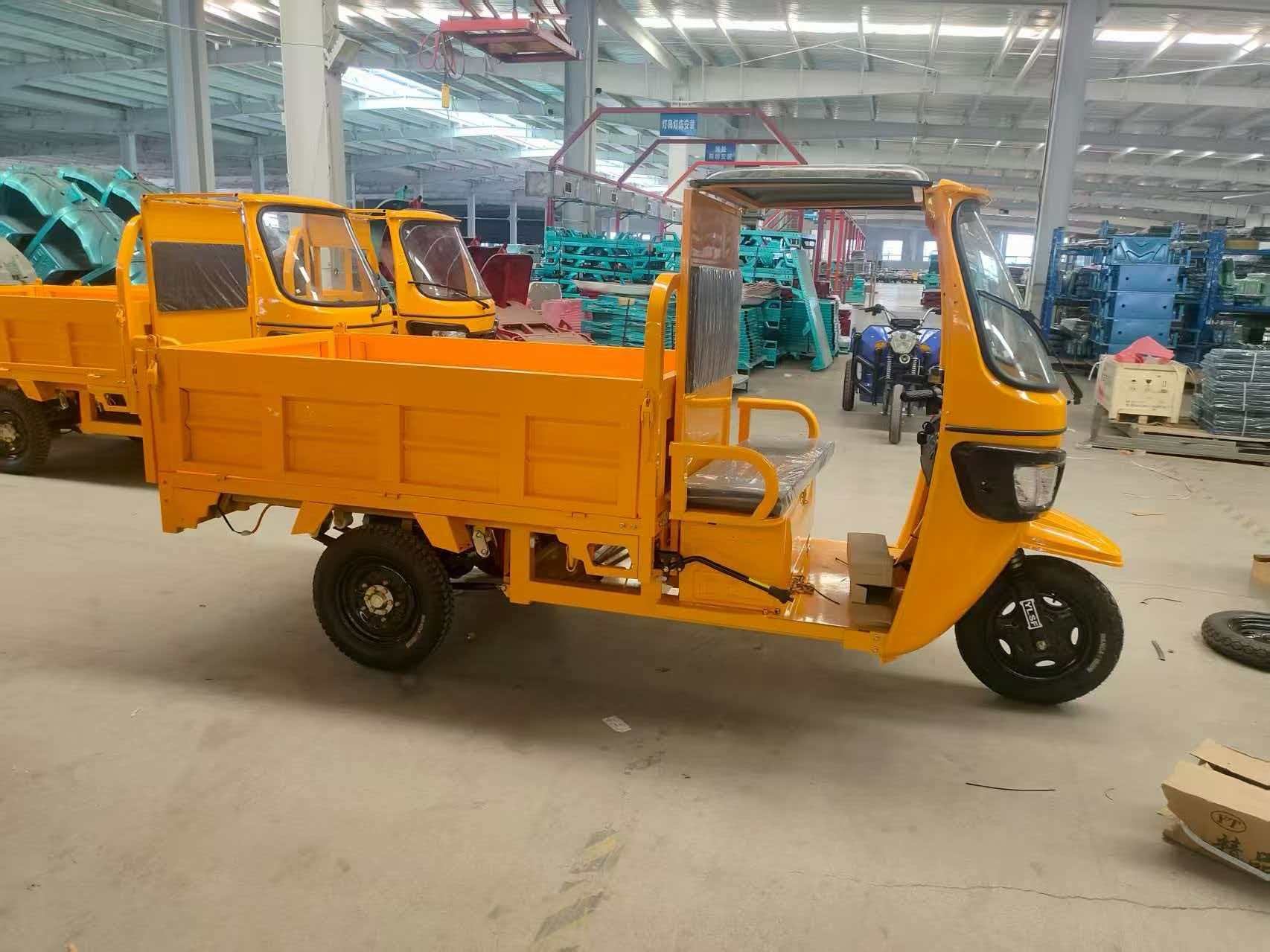 Yellow electric flatbed cargo tricycle in factory