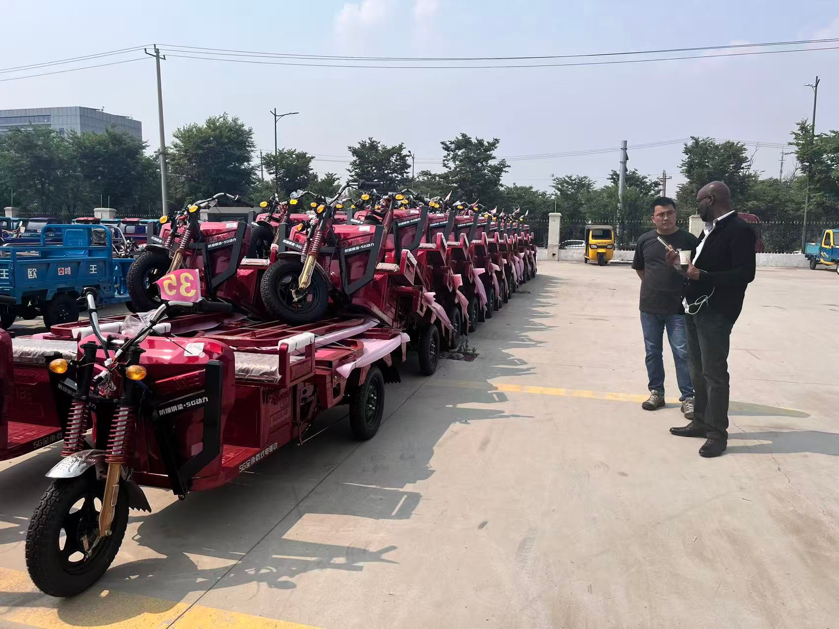 Row of red electric tricycles at factory lot